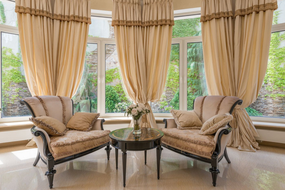 Living room with armchairs, curtains, and a flower vase